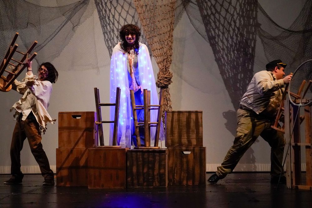 High school students performing on stage during a school play, colorful theater lights and expressions captured by SRX Media Group.
