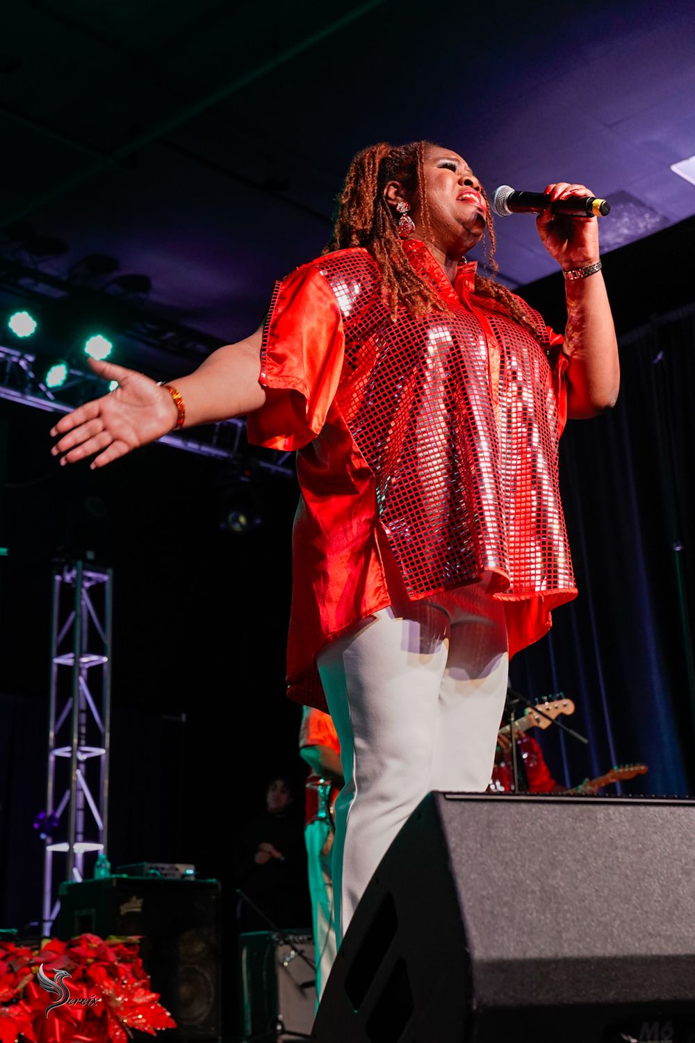 Musician performing live on stage under colorful concert lights, high-energy live music event photography by SRX Media Group