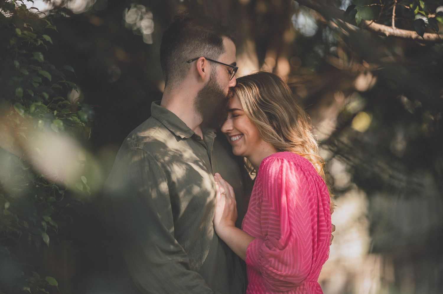 Couple sharing an intimate moment outdoors with bokeh lighting effects and autumn colors.