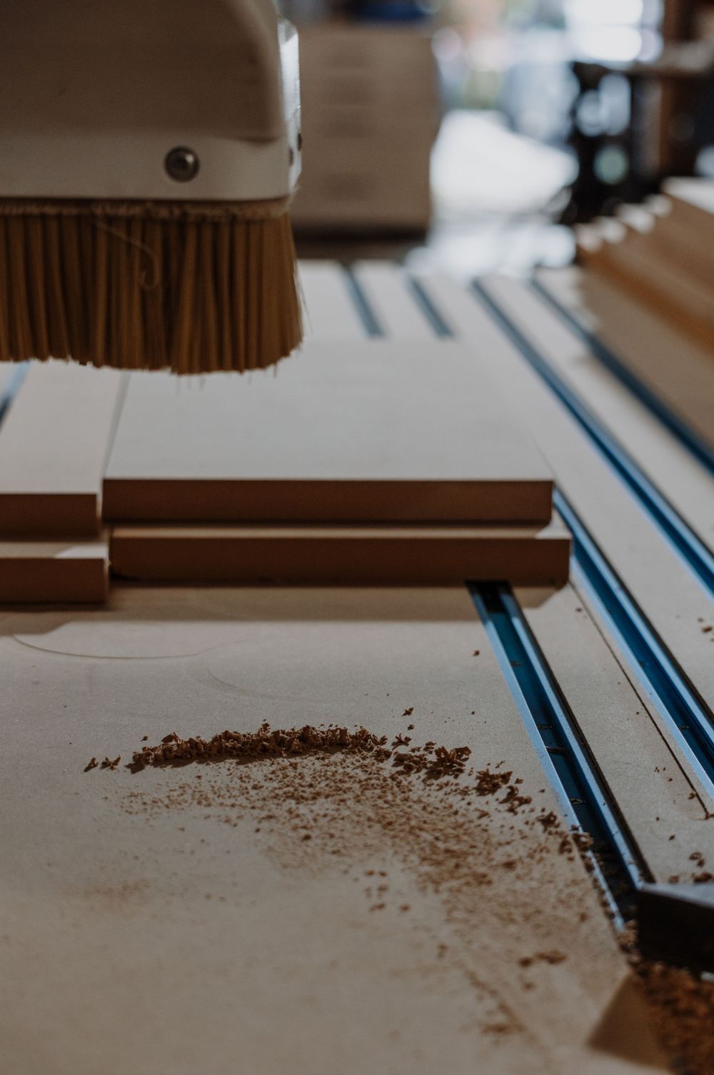 Close-up of sawdust being swept on a workshop surface.