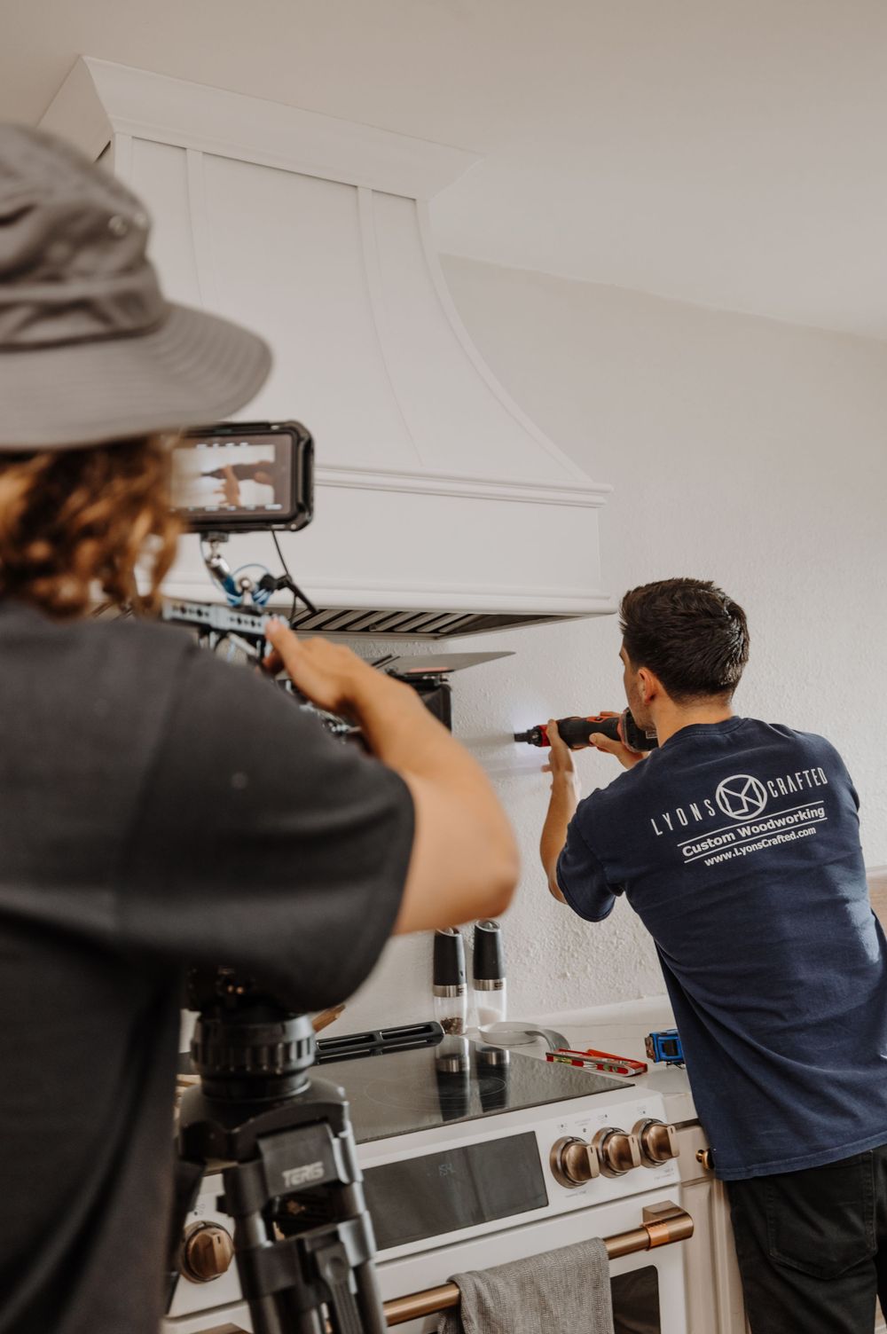 Workers installing equipment on a ceiling in a commercial space.