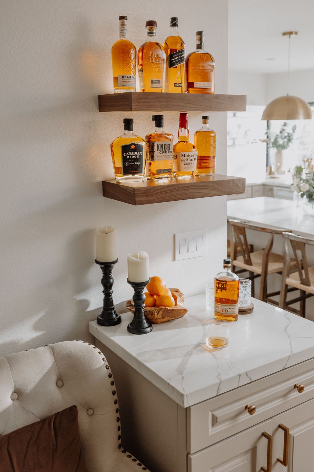 Collection of whiskey bottles displayed on floating wooden shelves.