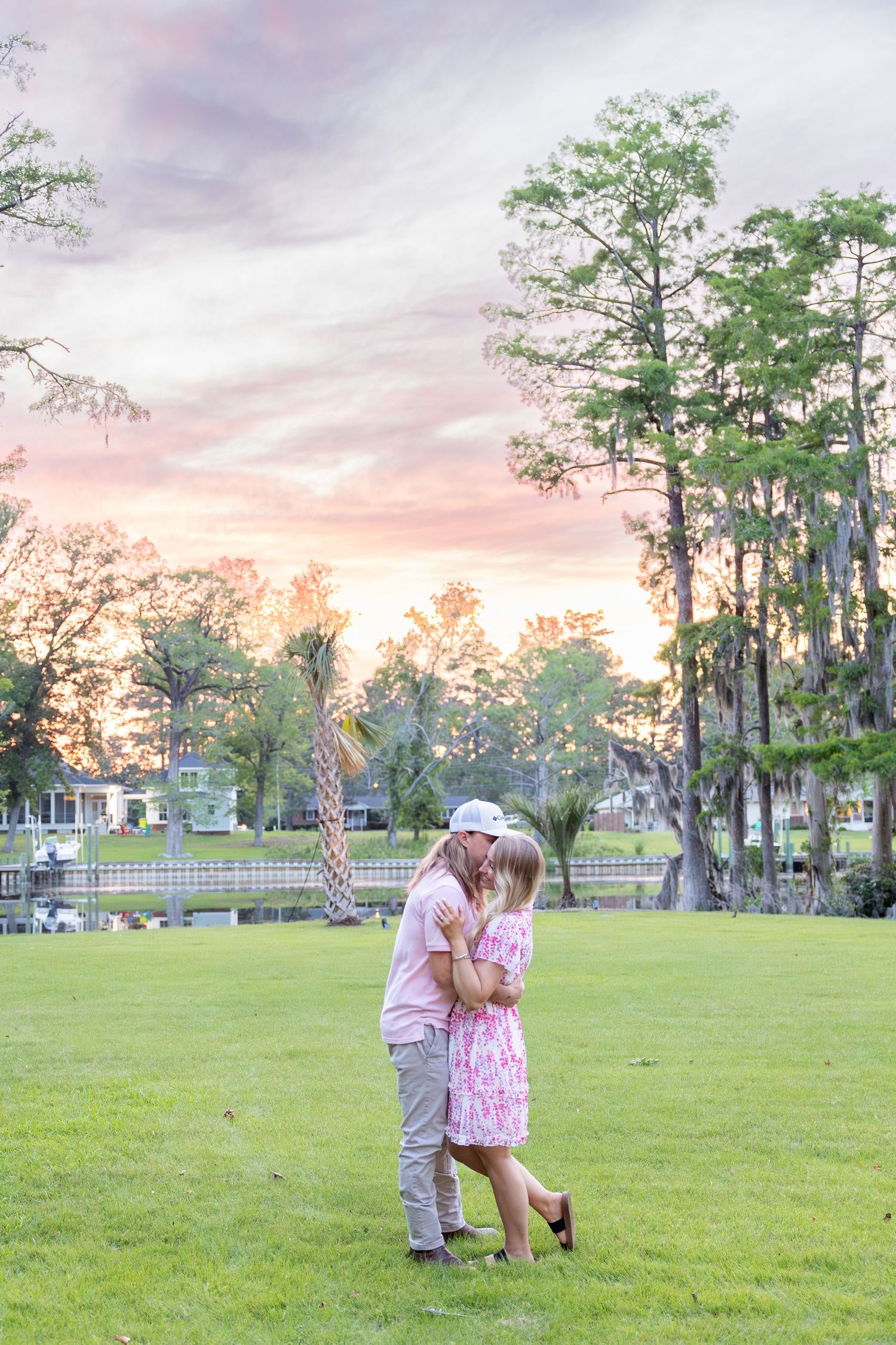 Romantic couple embraces in a moss covered background during sunset with trees in background (New Bern, NC).