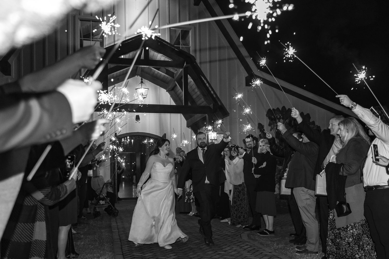 Wedding celebration with sparklers creating light trails in the dark (Raleigh, NC).