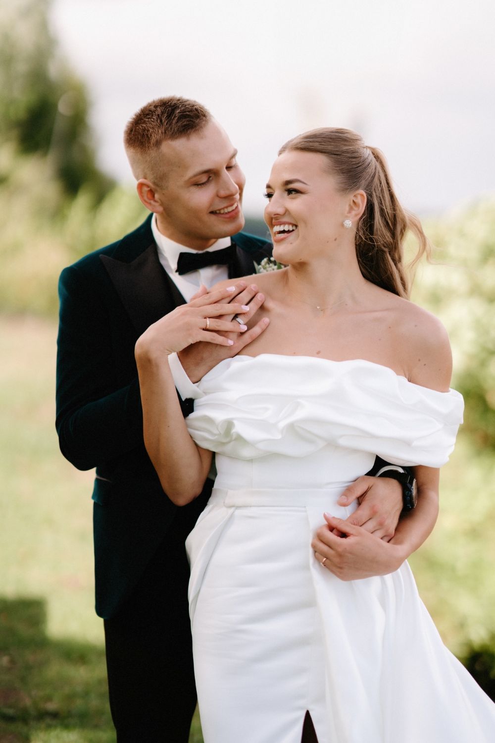 Romantic moment between newlyweds in elegant wedding attire outdoors.