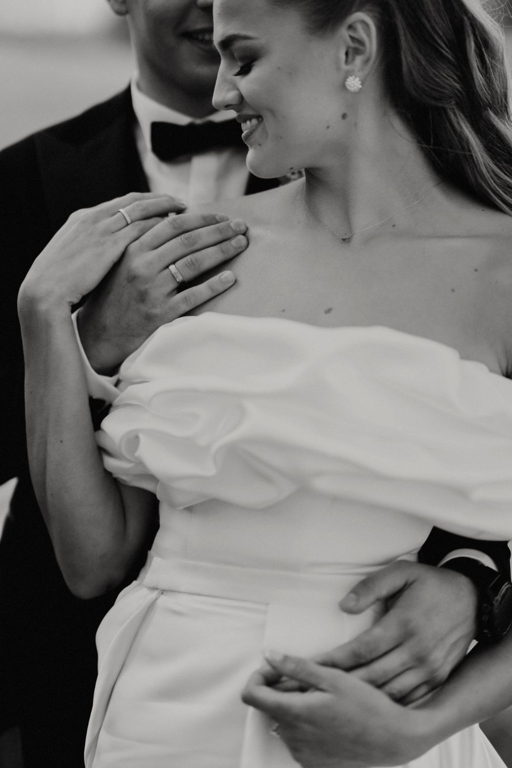 Intimate black and white portrait of newlyweds sharing a tender embrace.