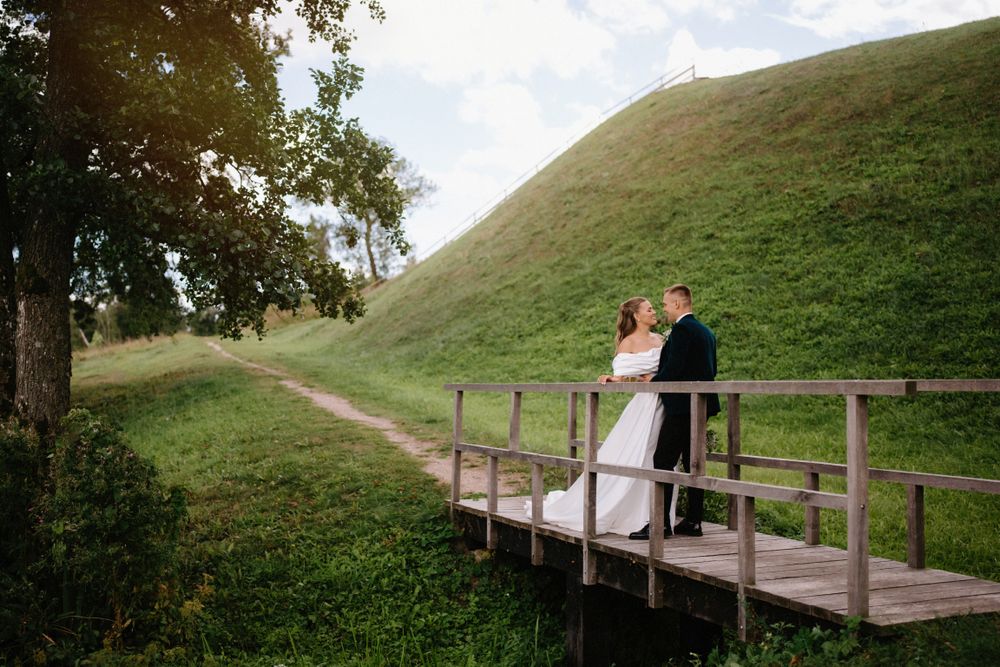 Scenic wedding photos taken on a wooden boardwalk with rolling hills in the background.