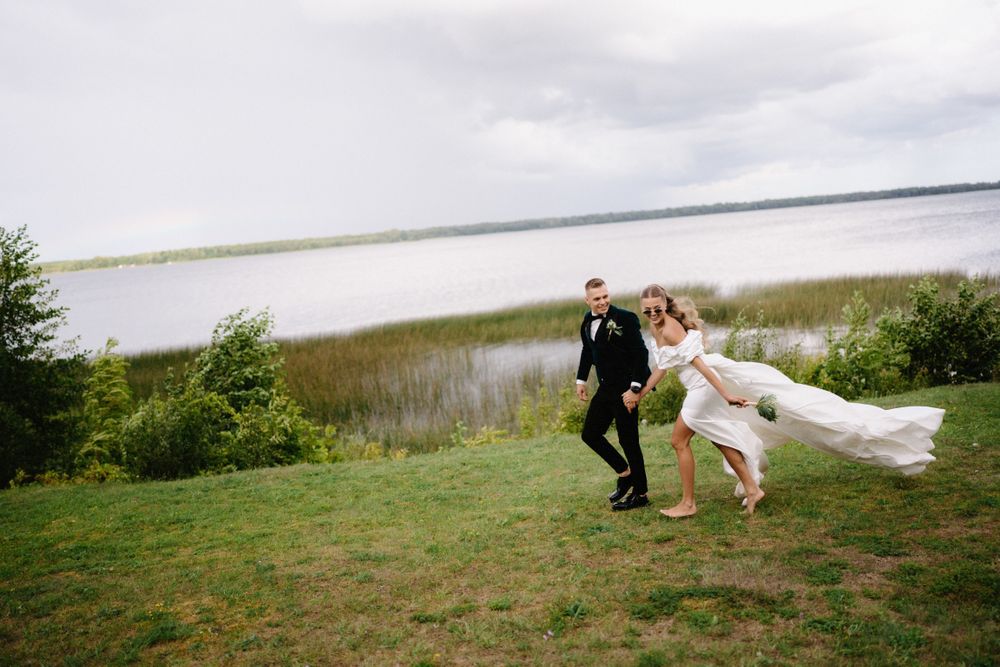 Wedding couple dancing in an open field with dramatic flowing dress movement.