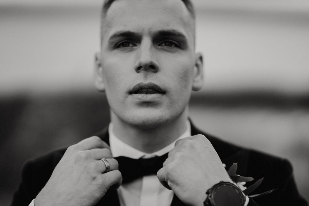 Close-up black and white portrait with dramatic lighting and formal attire.