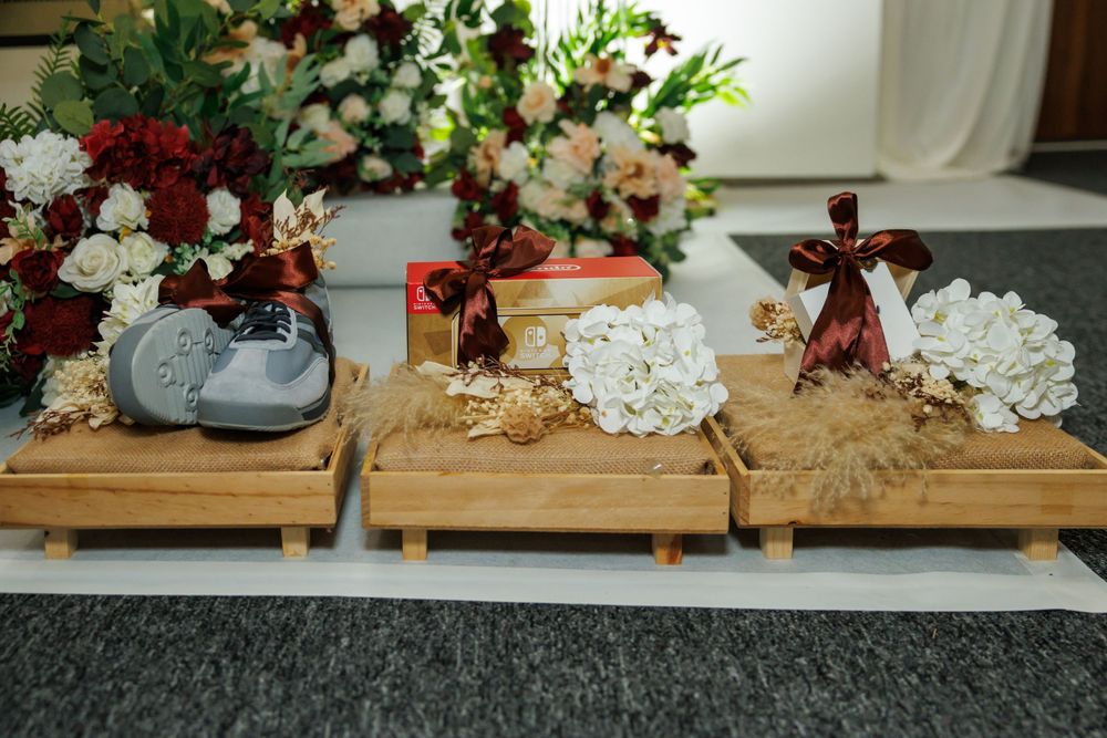 Decorative wooden display platforms with flowers and ceremonial items for a wedding.
