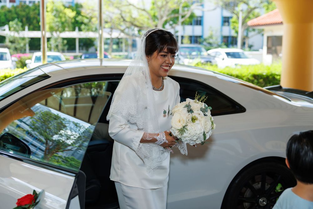 White decorated wedding car with bouquet being prepared for ceremony.