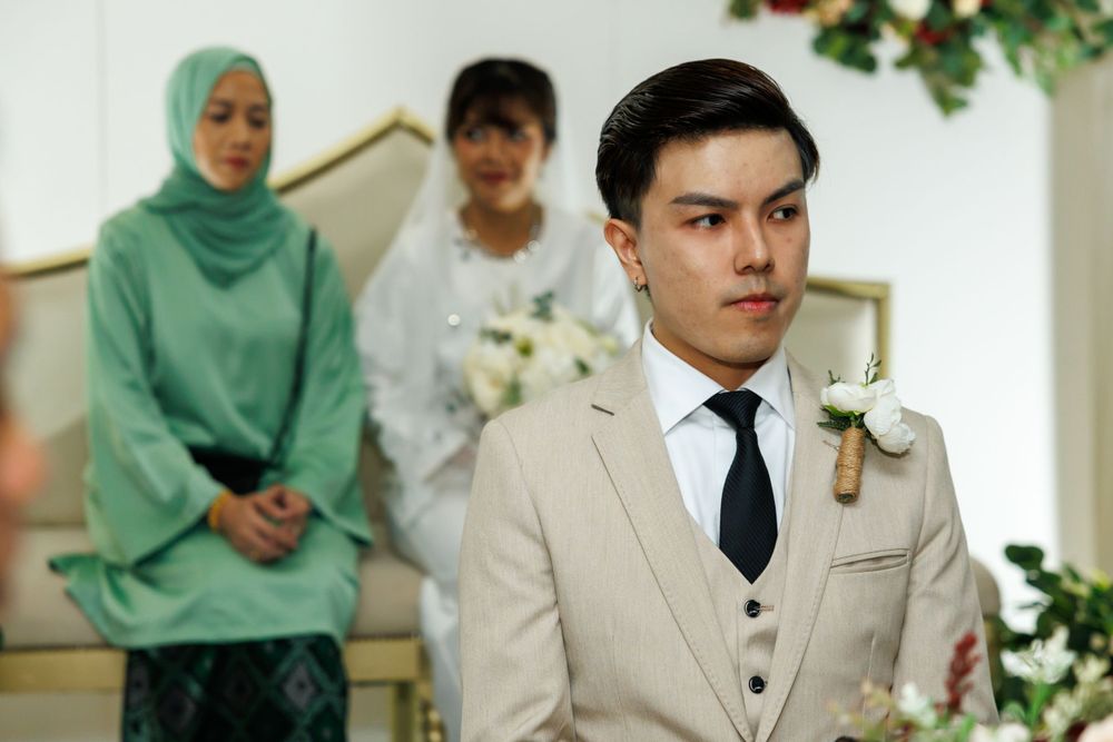 Elegant wedding ceremony scene with formal attire and floral decorations.
