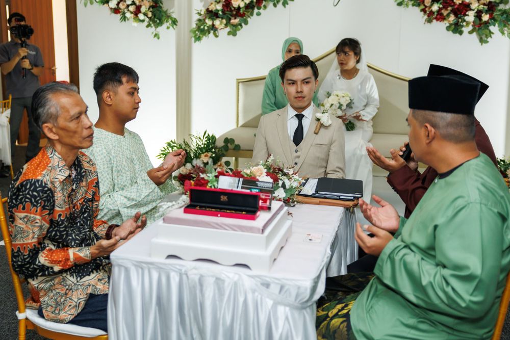 Traditional wedding ceremony gathering with guests and officials at decorated table.
