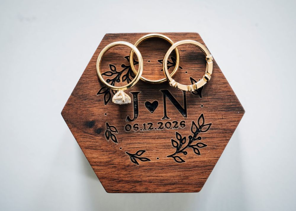 Personalized hexagonal wooden wedding ring box engraved with initials J and N and date 06.12.2026.