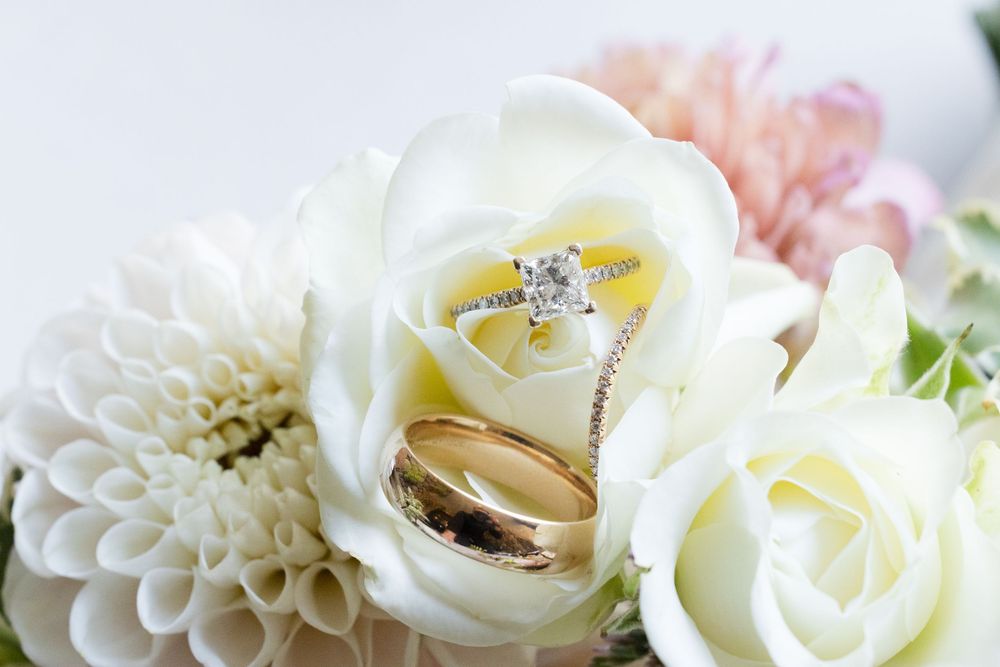 Delicate white and blush flowers including roses and dahlias arranged in a romantic wedding display.