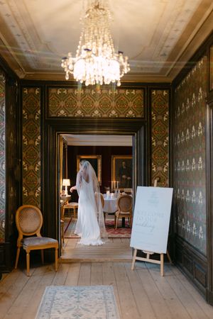 A series of elegant wedding photos in a vintage room with ornate wallpaper, chandeliers, and a bride in white.