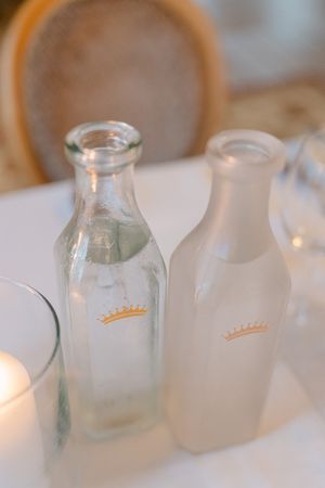 Glass jars and vases with soft white decor elements create an elegant table setting in natural light.