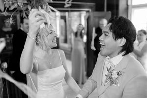 A joyful black and white photo of a dancing couple celebrating at their wedding reception.