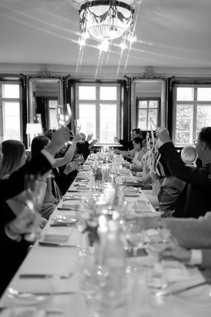 Black and white photo of a formal dining setup with multiple tables and guests in an elegant restaurant setting.