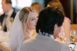 A wedding reception table setup with glowing candles and elegant place settings in a dimly lit room.