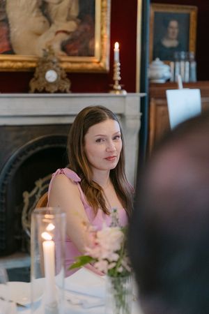 Elegant dinner setting with candlelight and portraits on the wall creates an intimate atmosphere.