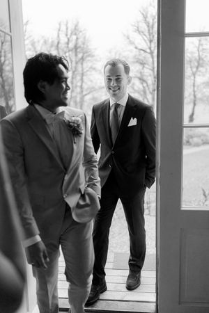 A black and white series of photos showing two people in suits laughing and having an animated conversation.