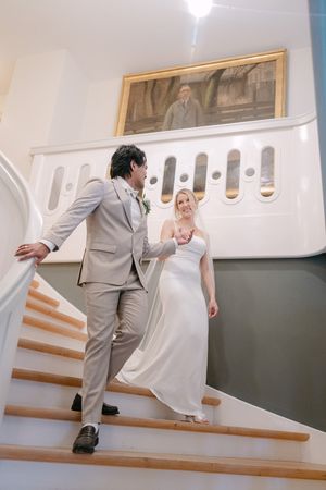 A playful sequence of wedding photos showing a couple interacting on a staircase with white walls.