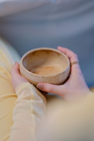 A series of hands holding ceramic coffee cups showing a progression of different angles and grips.