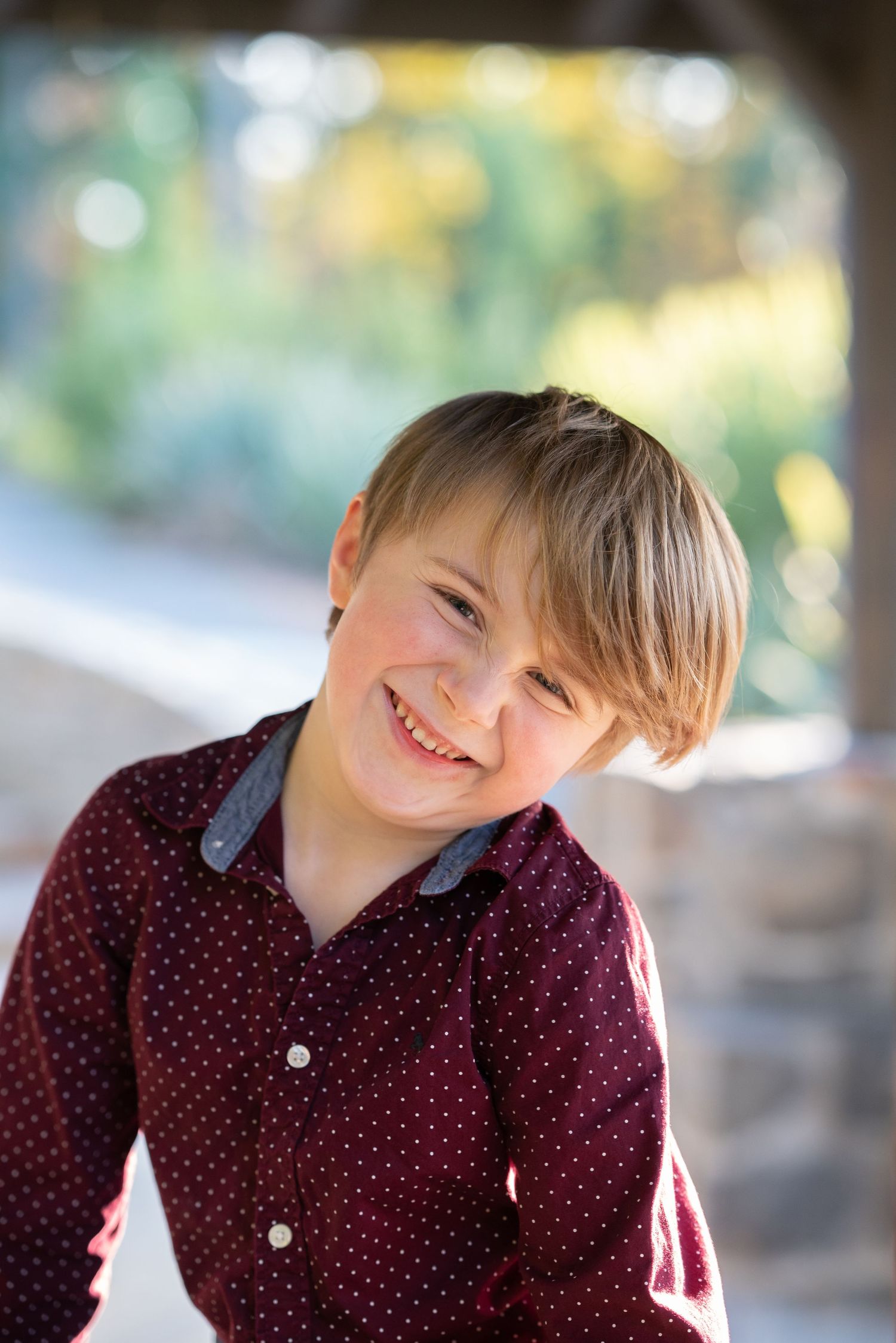 A sequence of photos showing someone in a burgundy polka dot shirt making playful expressions outdoors.