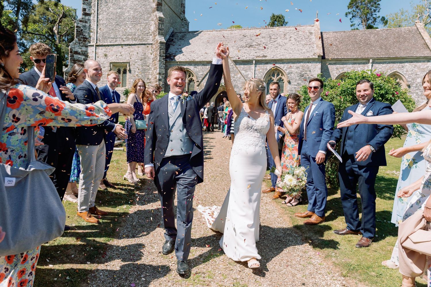 Confetti throw outside Lulworth Church on the grounds of Lulworth Estate, candid photography by Maddie Waters