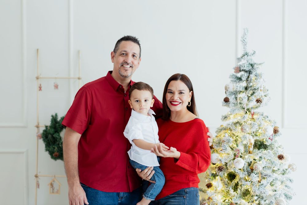 Family wearing red and white coordinated outfits for Christmas photo.