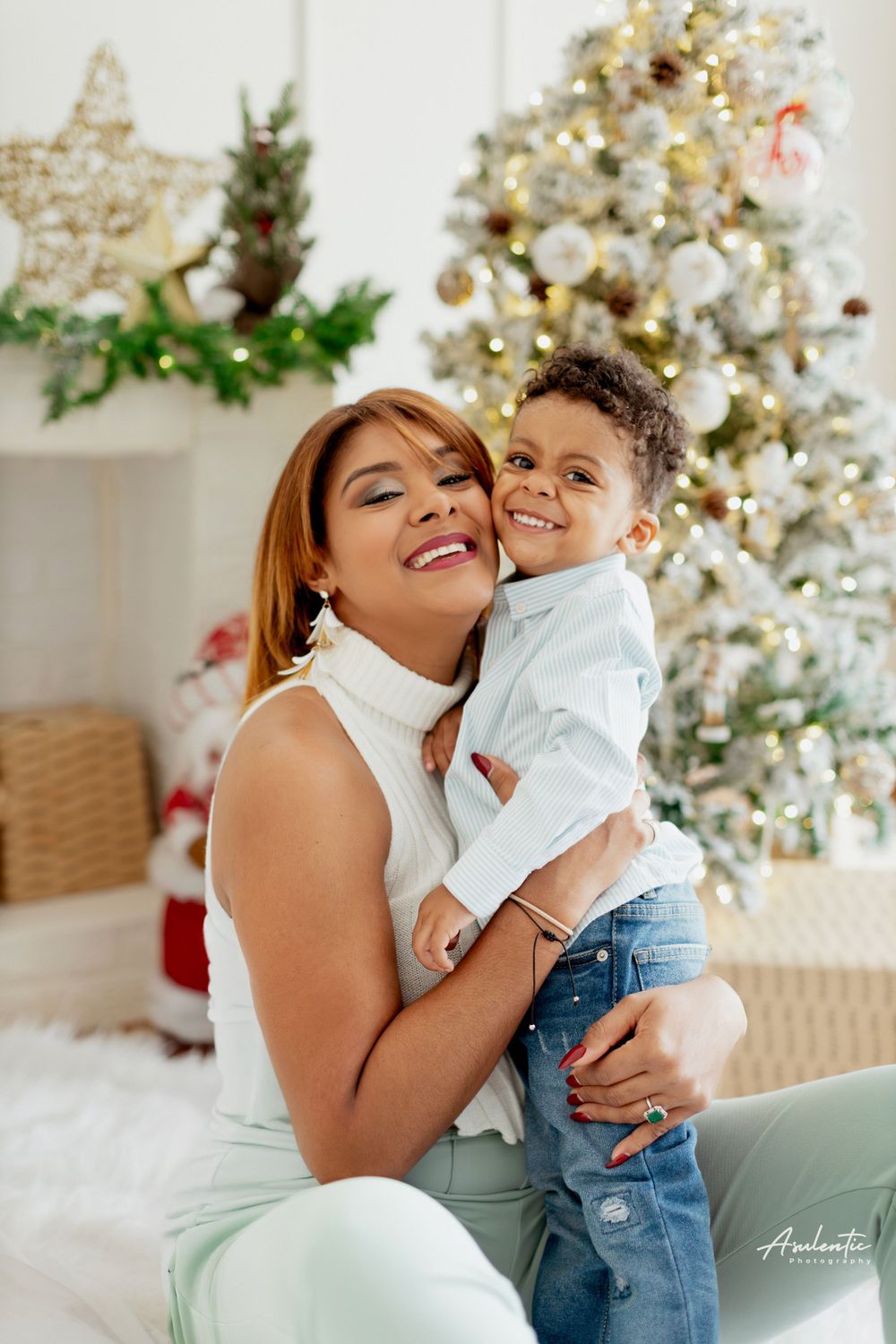 A heartwarming holiday portrait against a decorated Christmas tree with twinkling lights and festive decor.