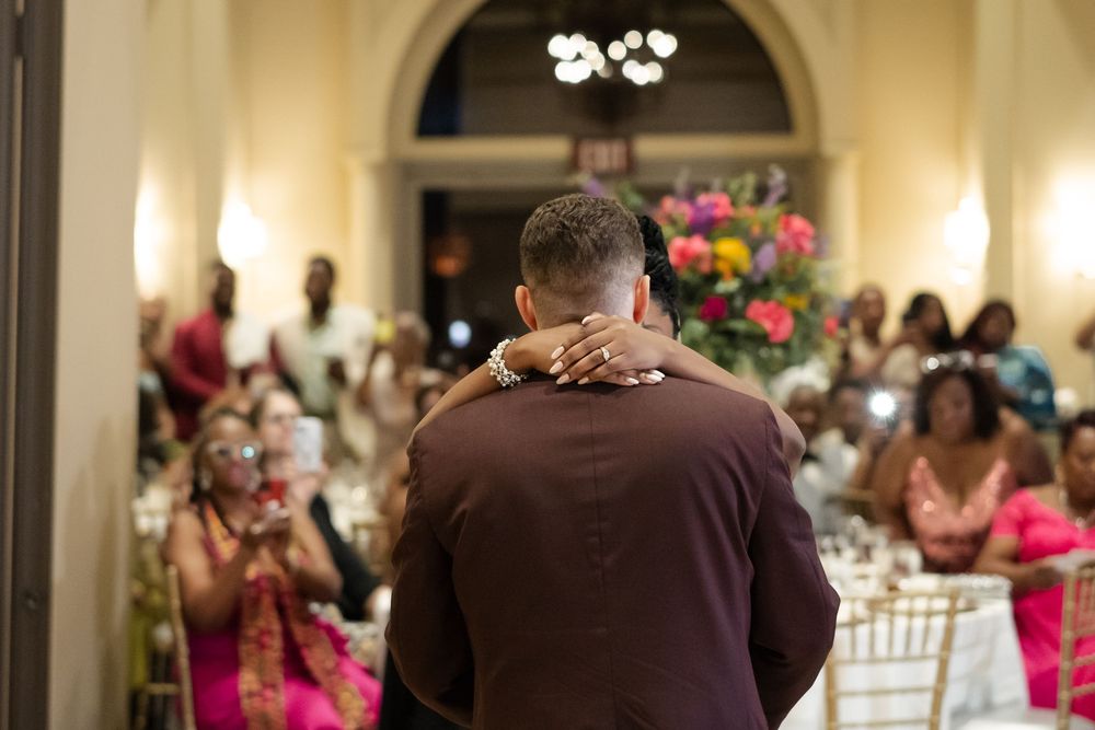 A couple shares their first dance at a wedding reception in an elegant ballroom with guests watching. Las vegas wedding photographer.