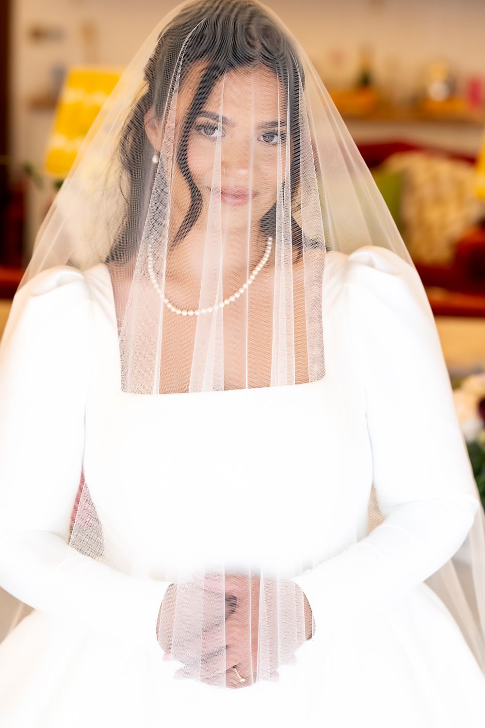 A bride wearing a white dress and long veil poses in a series of close-up shots with soft lighting.