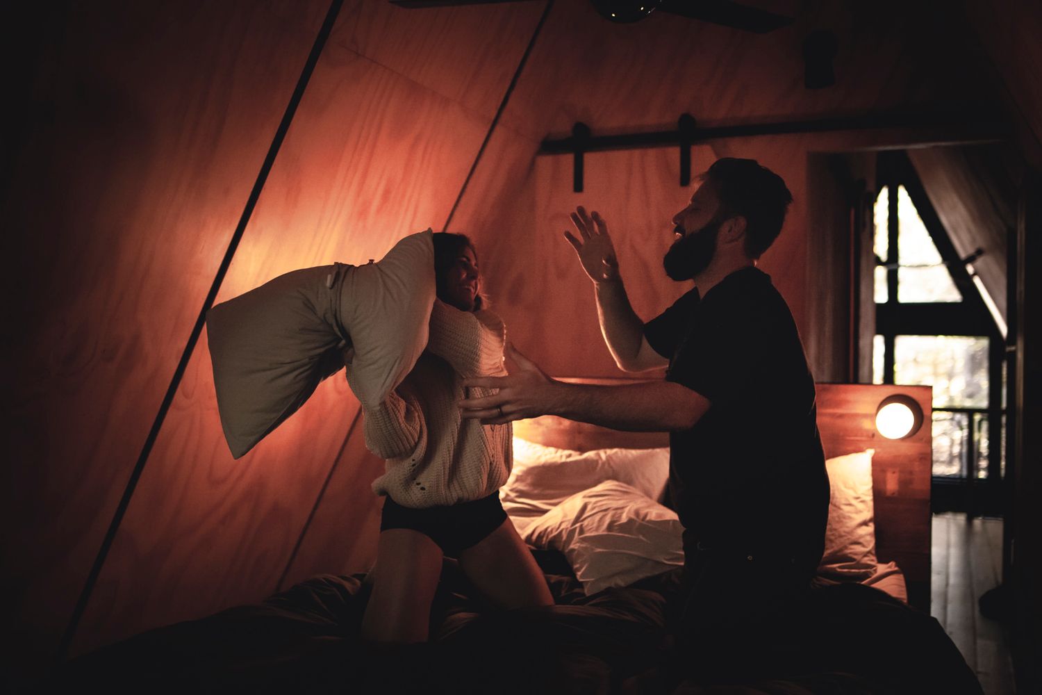 visiting couple has playful portraits taken B&B loft bedroom near thousand islands ontario