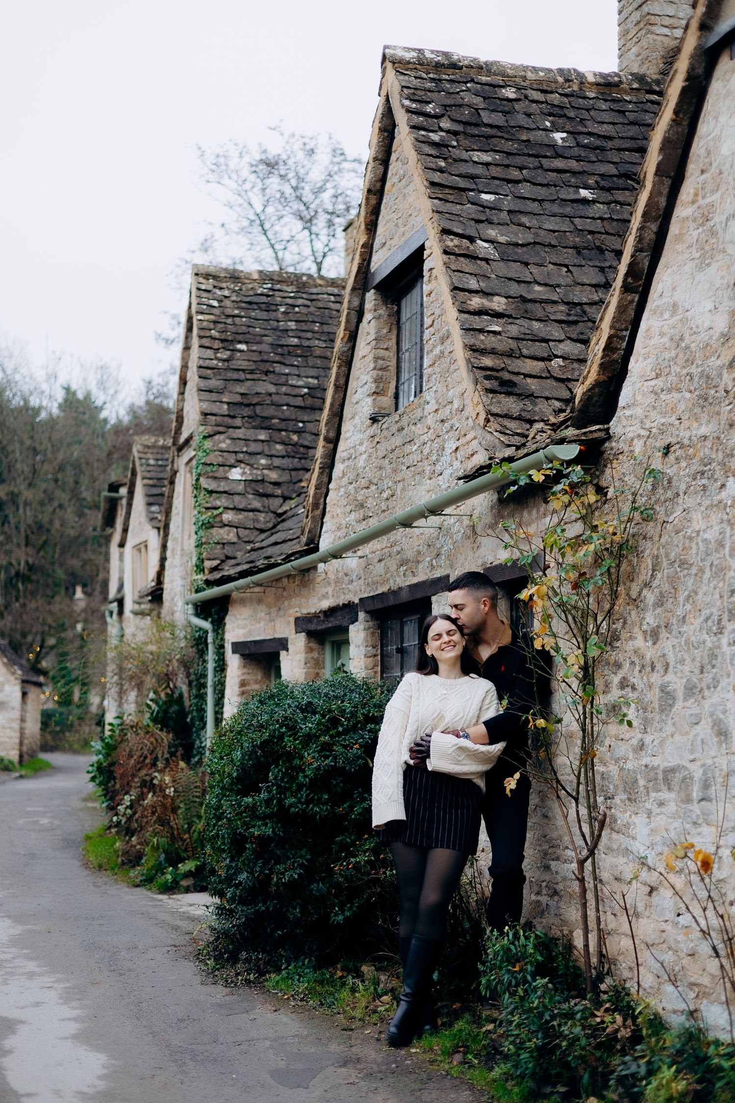 Stone cottages with slate roofs line a quaint village path in the English countryside.