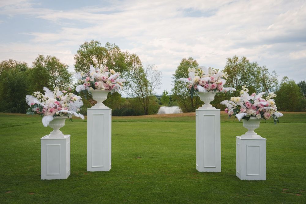 White decorative letters spelling LOVE sit arranged in a grassy field under cloudy skies.