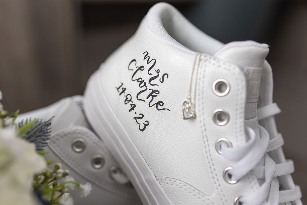 White Nike Air Force 1 sneakers with custom graffiti-style lettering and artwork displayed from multiple angles.