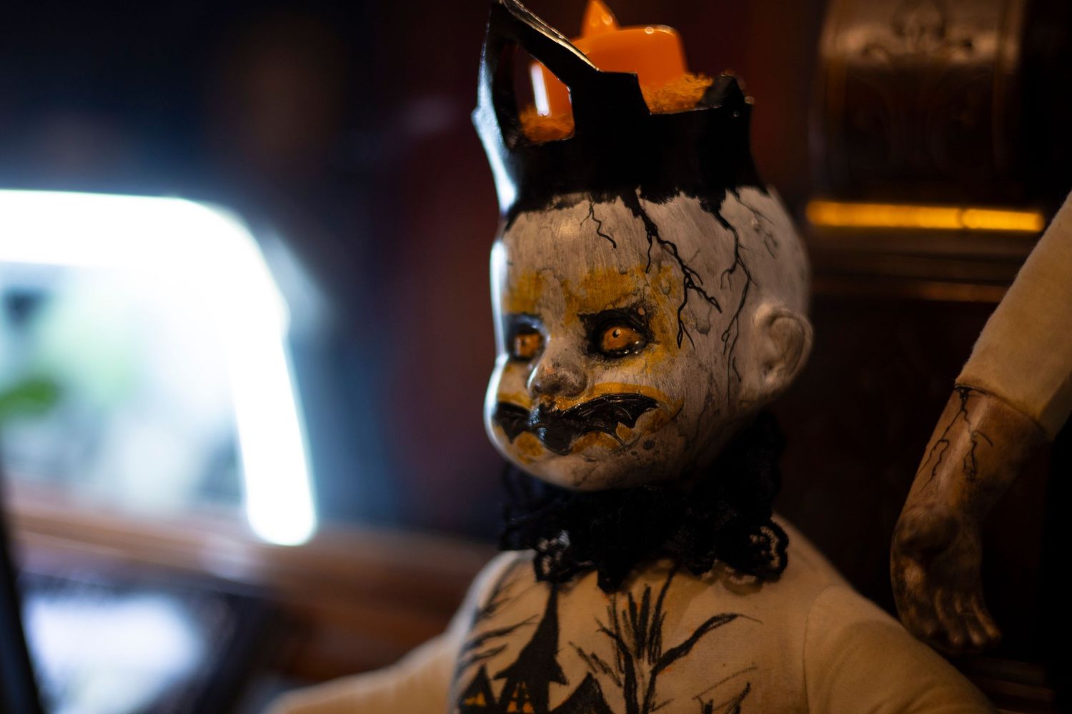 Spooky Halloween decorations featuring creepy doll figures and glowing lights in a dark haunted house setting.