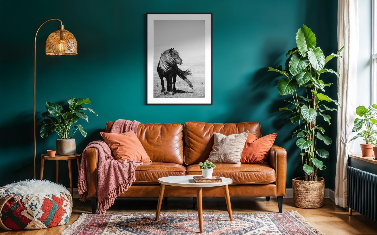 Gezellige woonkamer met groene muur en bruinleren bank, zwart-wit print van wild paard met wapperende manen en staart in de wind.