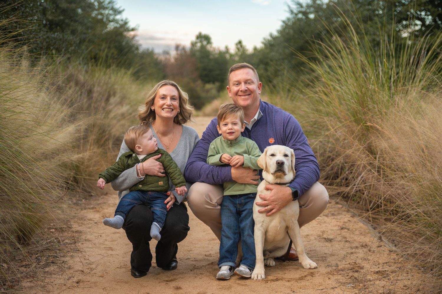 A sequence of outdoor family portraits with a dog on a nature trail during golden hour.
