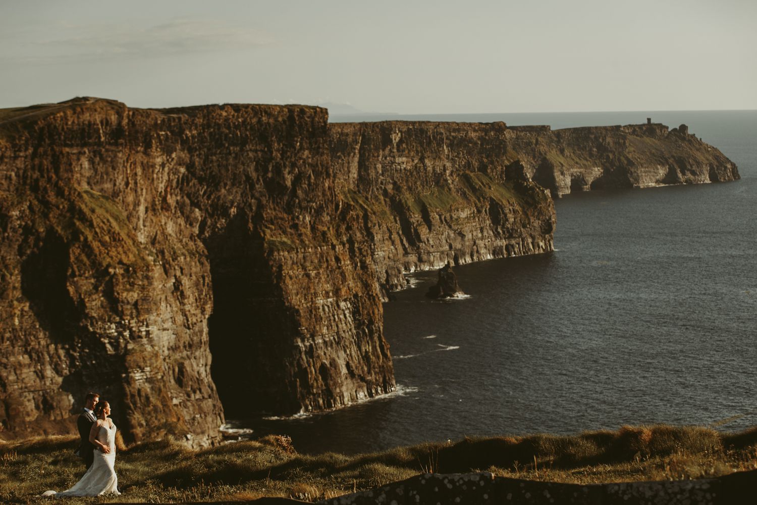 Dramatic coastal cliffs overlooking the ocean during golden hour.