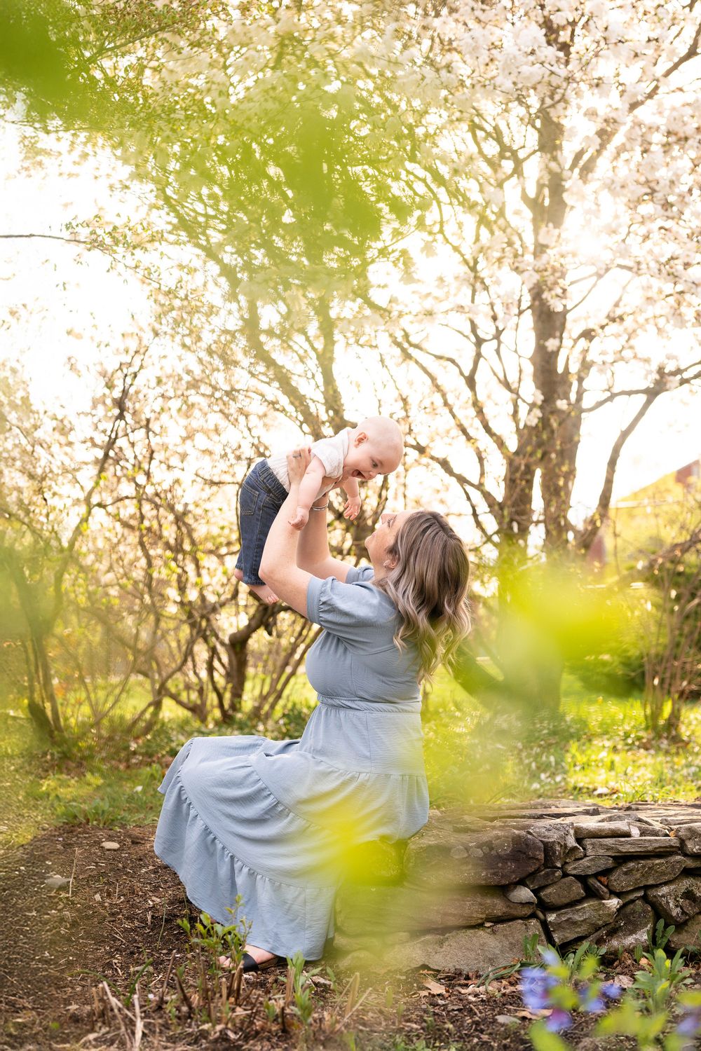 A series of dreamy springtime portraits showing someone in a flowy gray dress twirling among blooming trees at sunset.