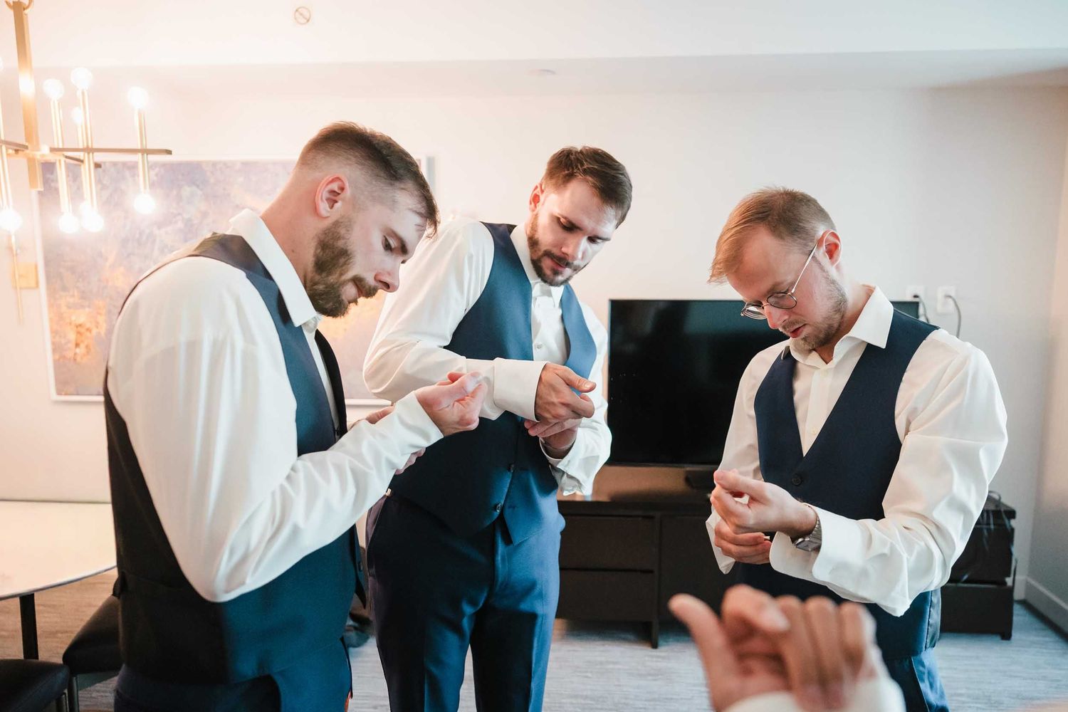 Groomsmen adjusting cufflinks and getting ready together before a Boston wedding ceremony