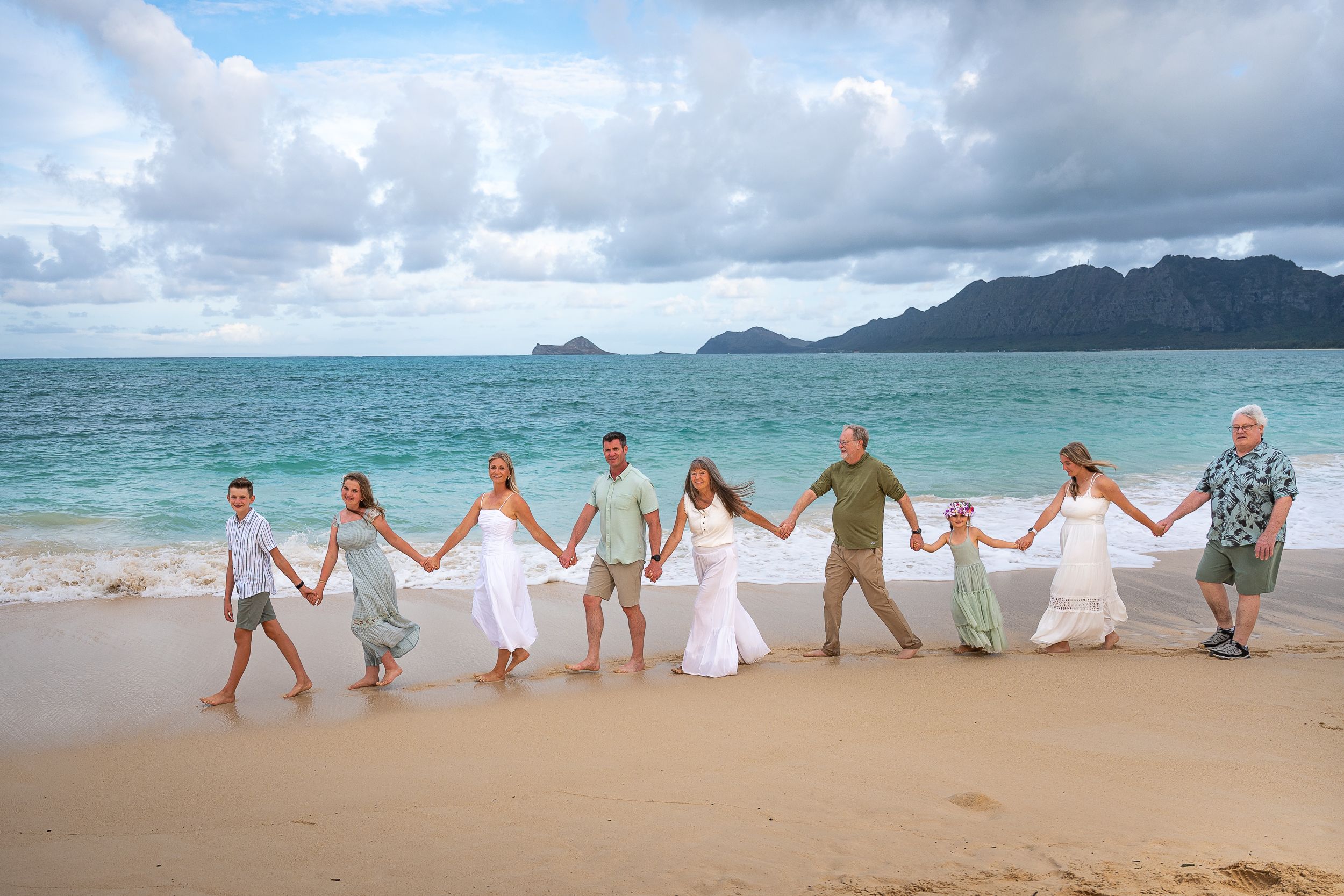 Large fun extended family in a big group Bellows Air Station Beach with Hawaii family photographer Jenna Ettlich with turquoise waters.