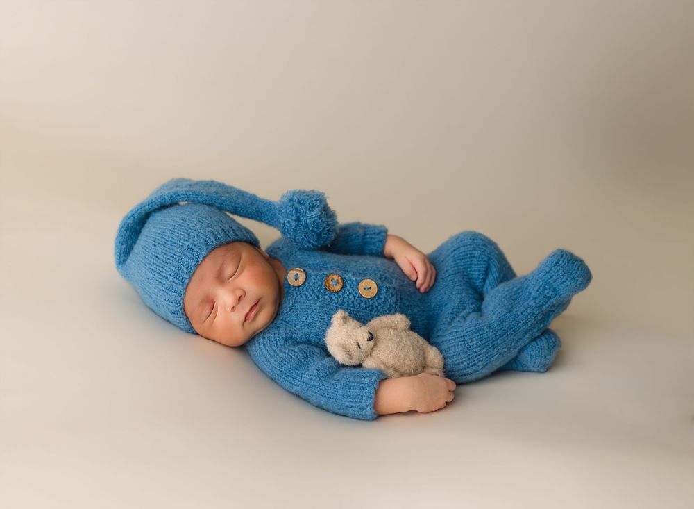 Newborn baby posed in a blue outfit during a studio newborn session