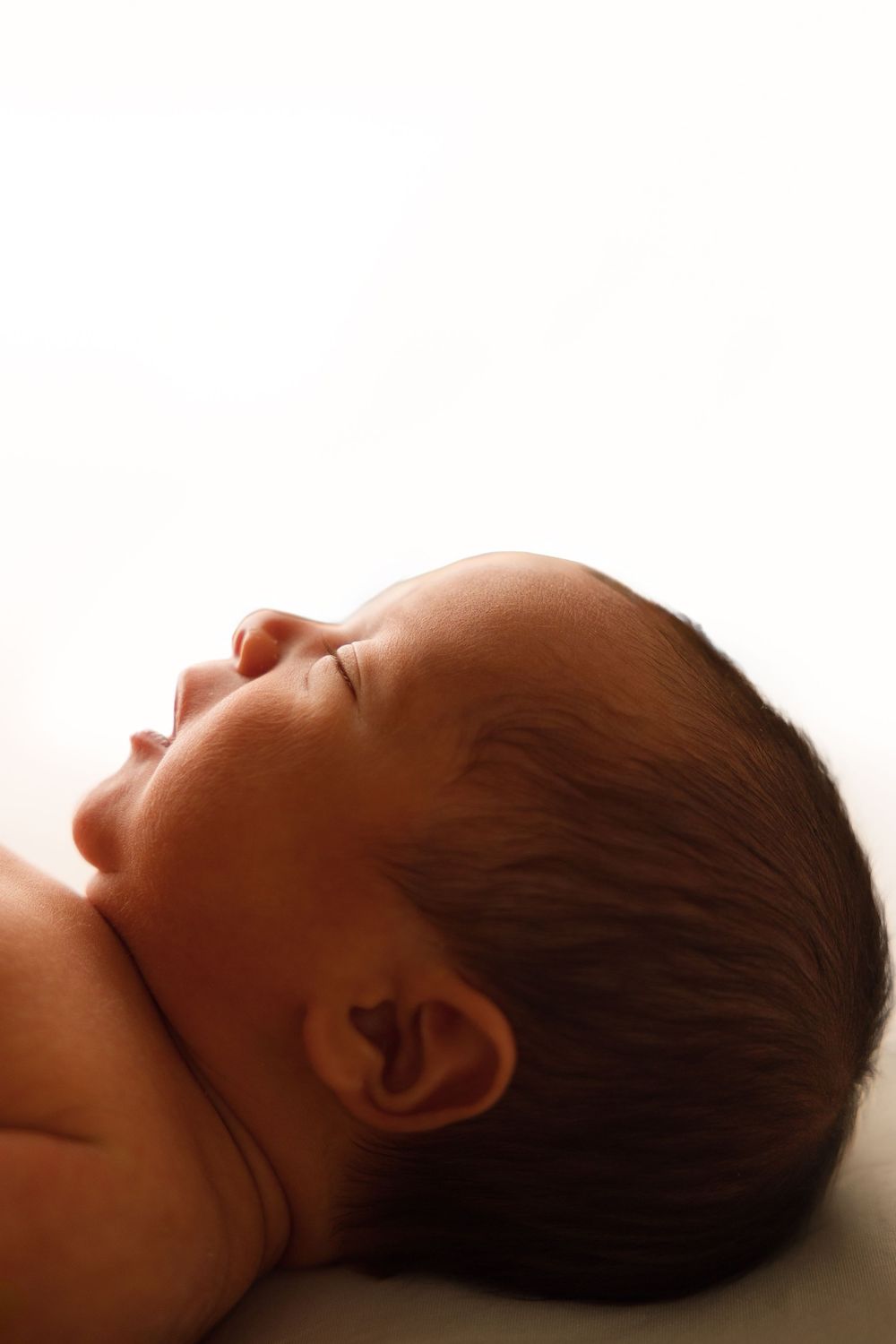 Artistic side profile of a newborn baby during a studio session