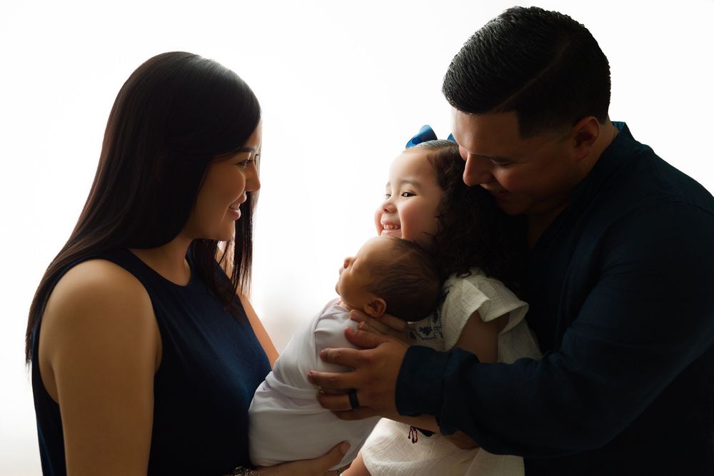 Parents holding their newborn baby during a family newborn portrait