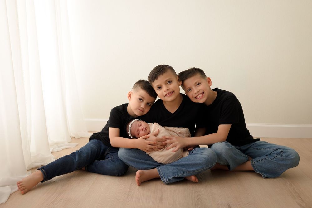 Three brothers posing together during a studio newborn/sibling portrait session