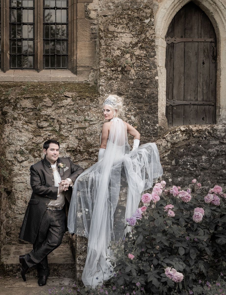 Stylish portrait of bride and groom on medieval steps of Allington Castle in Kent.